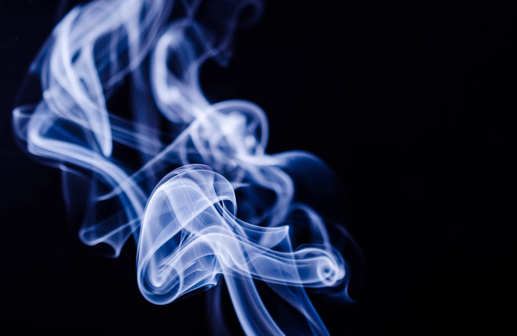 white smoke curling upward om a black background
