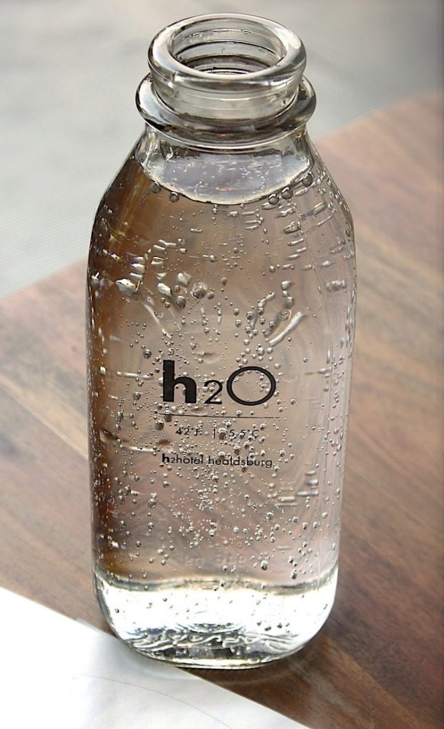 small bottle fille with water and h2O written in black on side of bottle